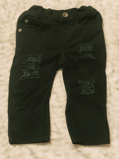 Black Distressed Jeans on beige background