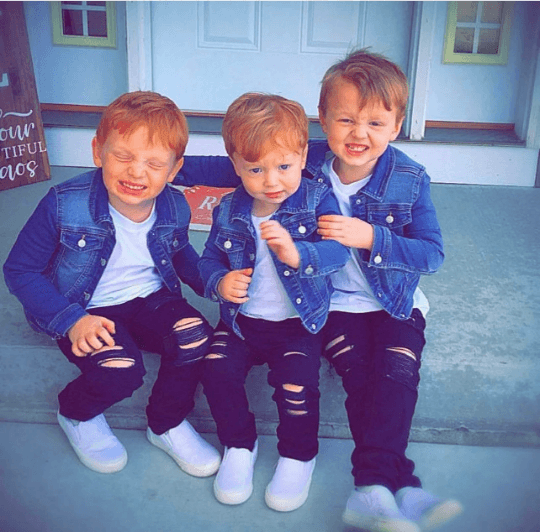 Black Distressed Jeans models by 3 young boys in matching jeans jackets, black jeans and white shirts with white sneakers on porch step.