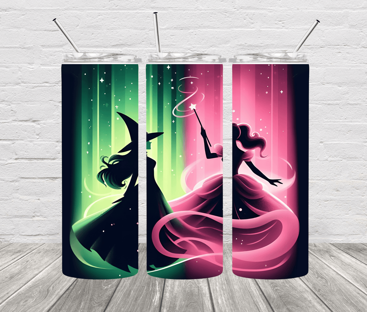 A set of two stainless steel tumblers with one featuring a green witch design and the other a pink princess design, both with black backgrounds and colorful accents, displayed against a white brick wall.