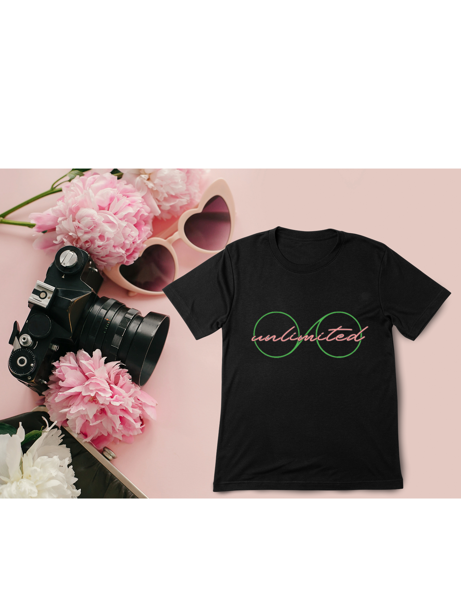 Black t-shirt with 'unlimited' design on a pink surface with camera, sunglasses, and flowers.
